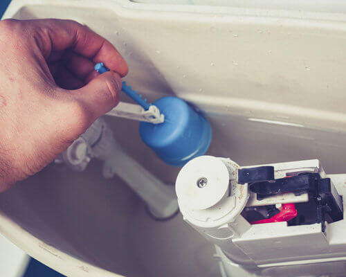 Man Replacing Toilet Flush Valve